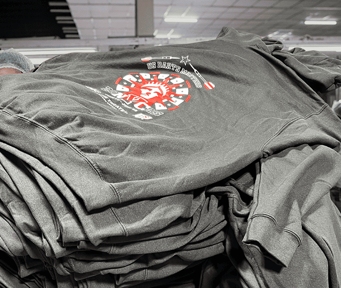 Stack of custom bulk black hoodies with US DARTS MASTERS logo print