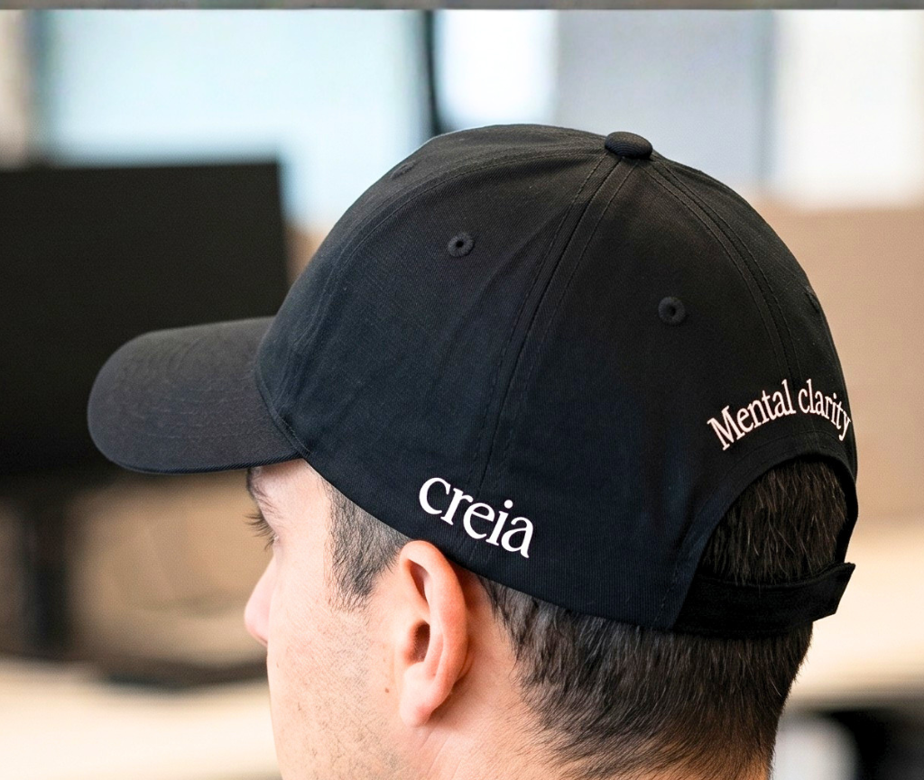 Side view of a custom embroidered black baseball cap with branded text on the back, designed for corporate branding and promotional apparel.
